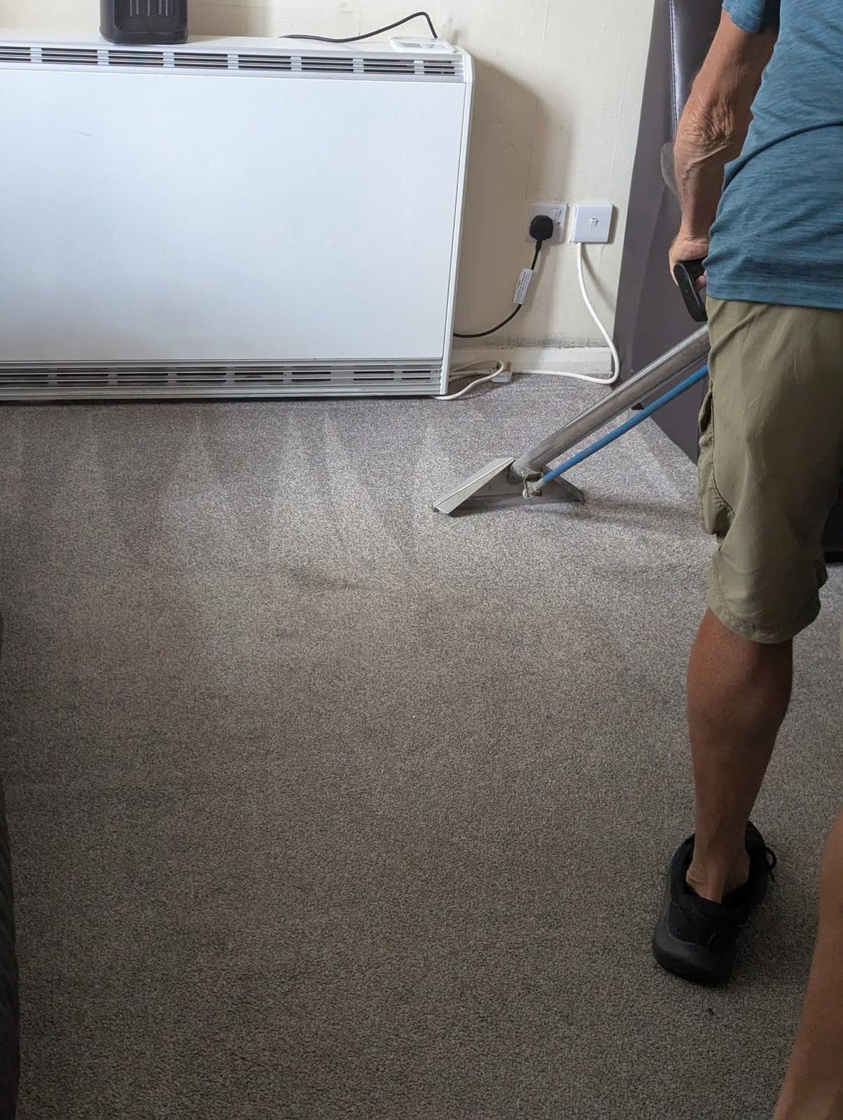Professional carpet cleaning in progress with hot water extraction equipment